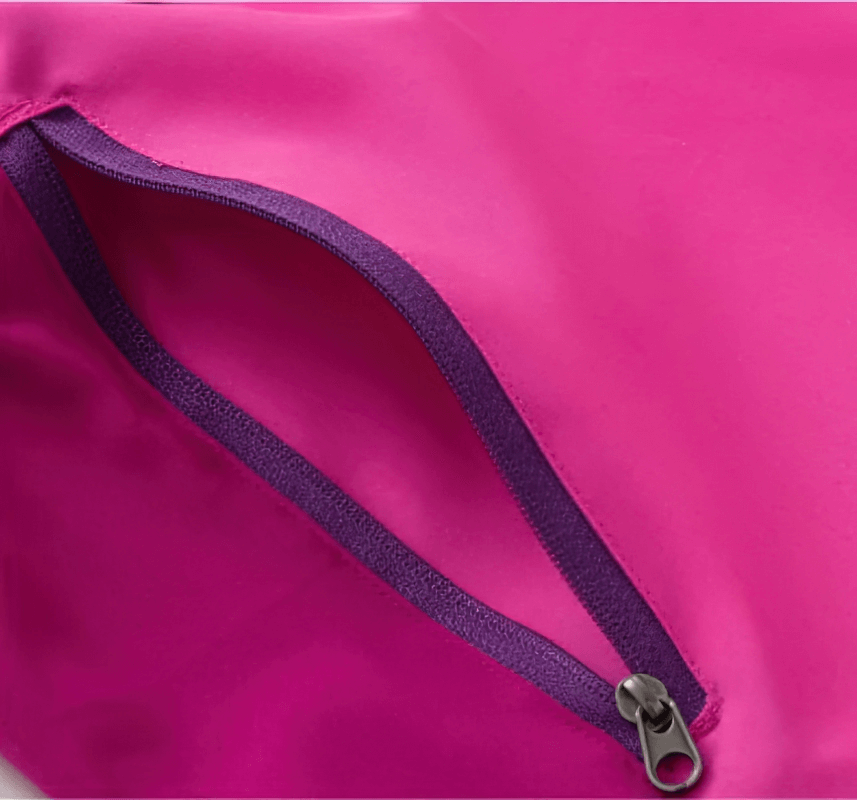 Close-up of a pink zipper pocket on breathable quick-drying women's hiking pants, showcasing durable Drytek material.